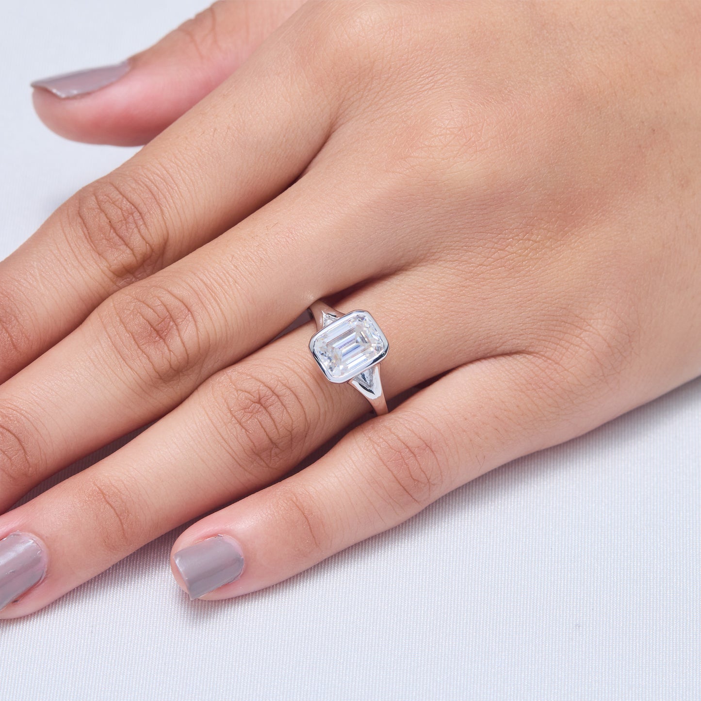 9x7mm Emerald Cut Moissanite Engagement Ring: Silver Bezel Split Shank Design