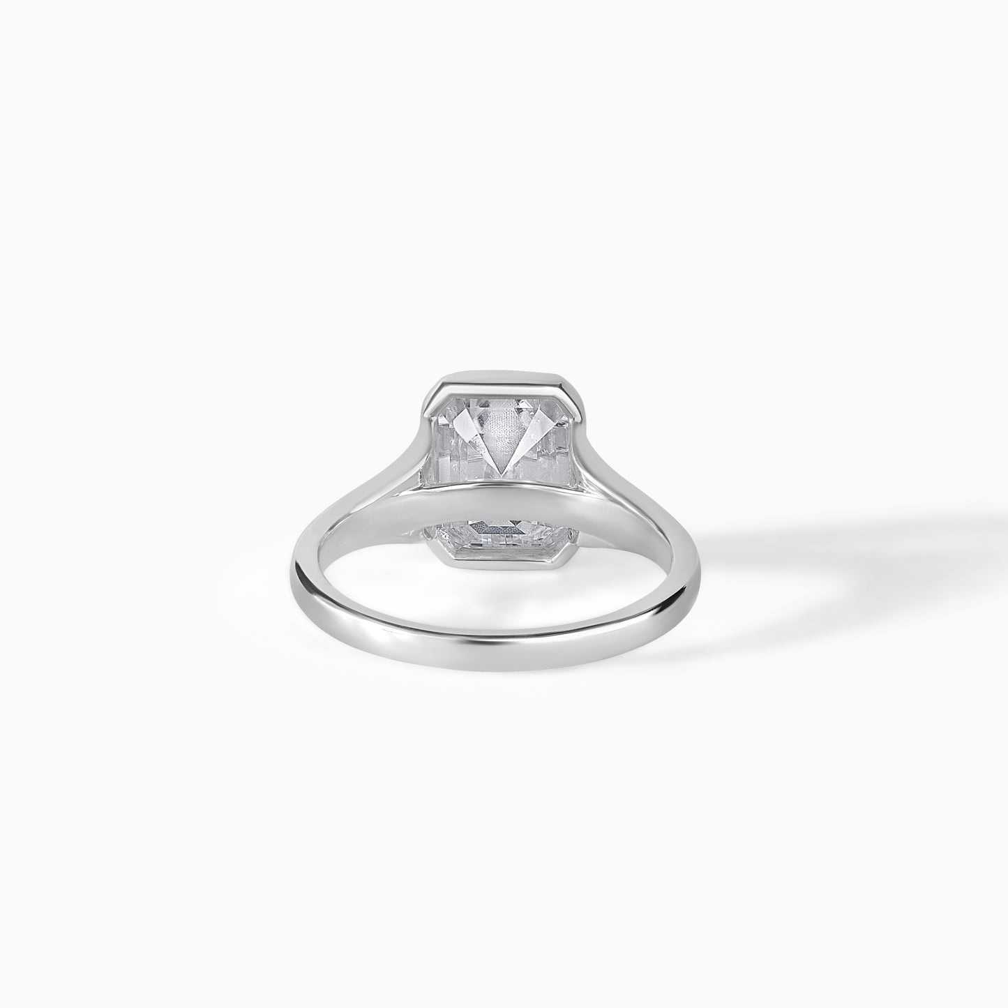 9x7mm Emerald Cut Moissanite Engagement Ring: Silver Bezel Split Shank Design